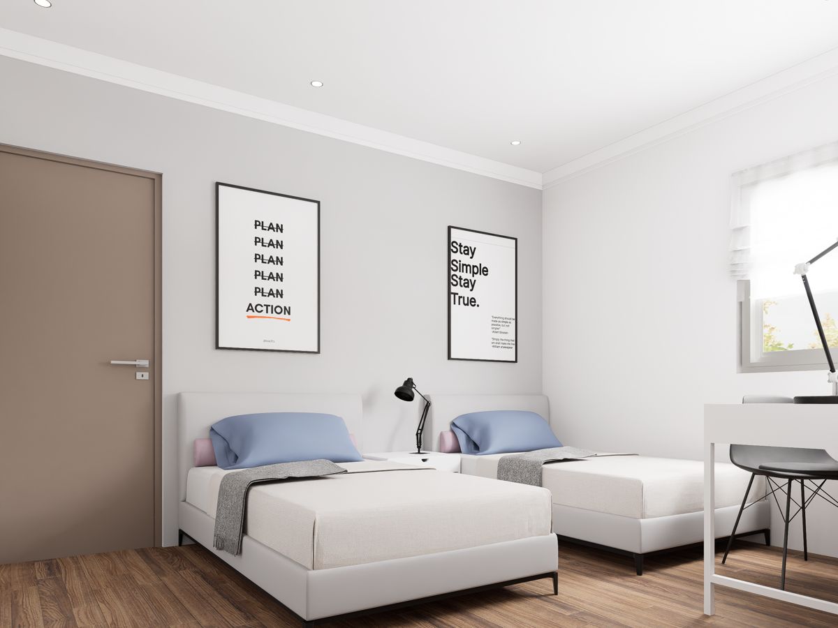 Furnished resident room with two beds, desk, and natural light